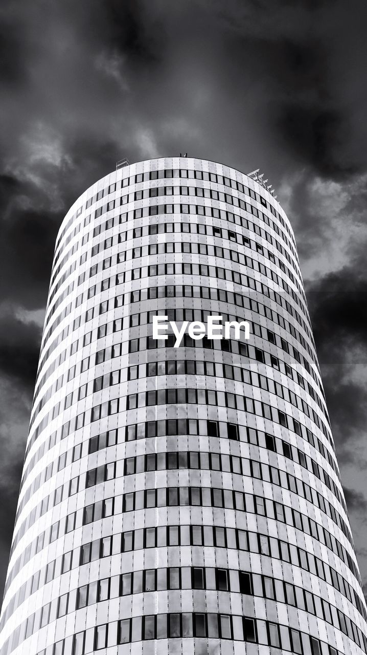 Low angle view of modern building against cloudy sky