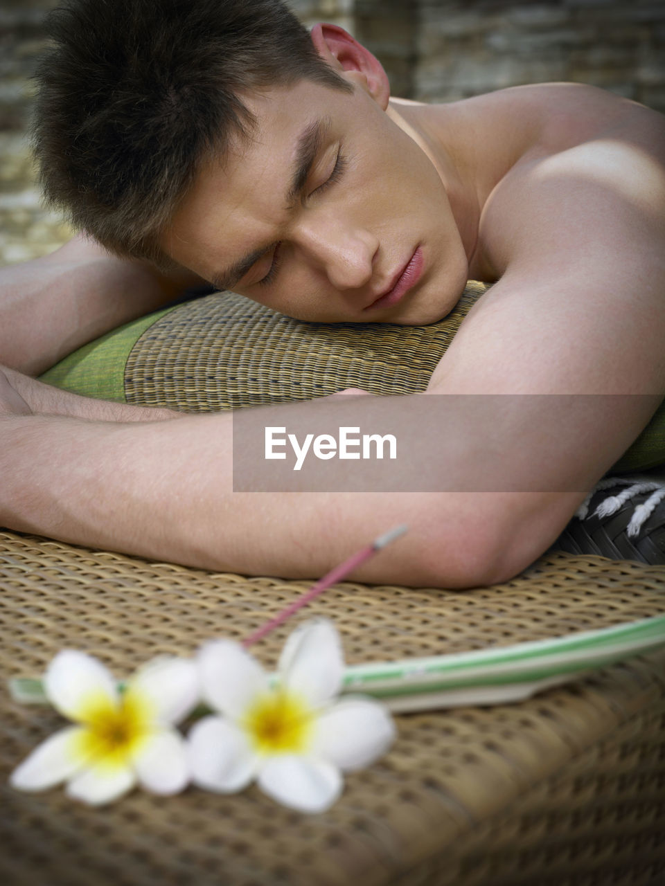 Shirtless man lying on poolside