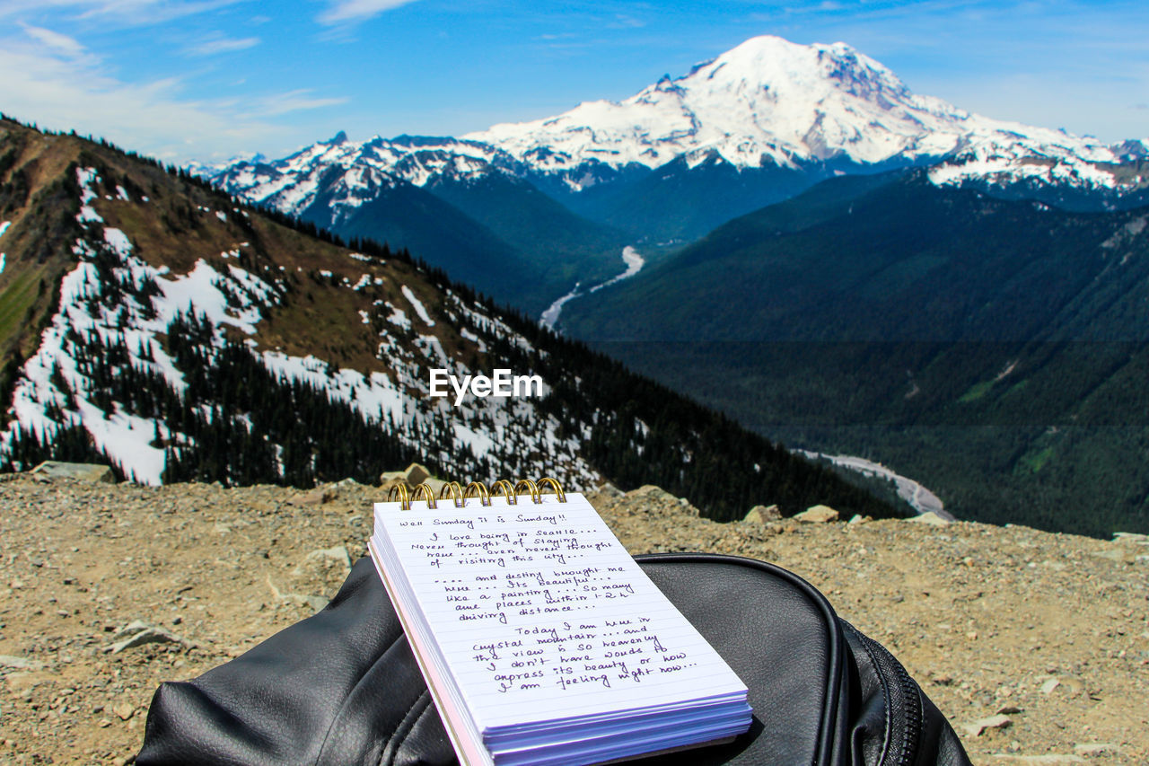 Scenic view of snowcapped mountains with someone writing blog