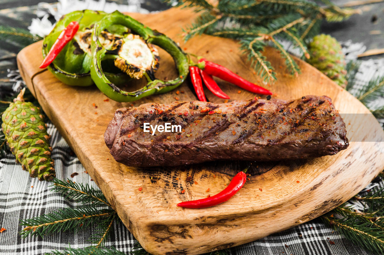 CLOSE-UP OF MEAT ON BARBECUE GRILL ON TABLE