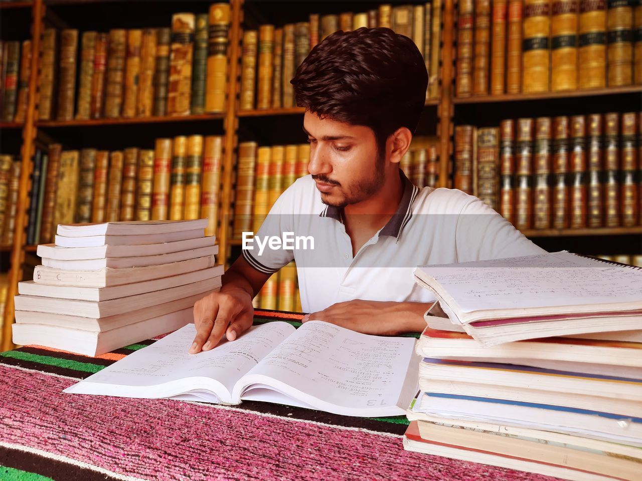 Close-up of young man reading book in library