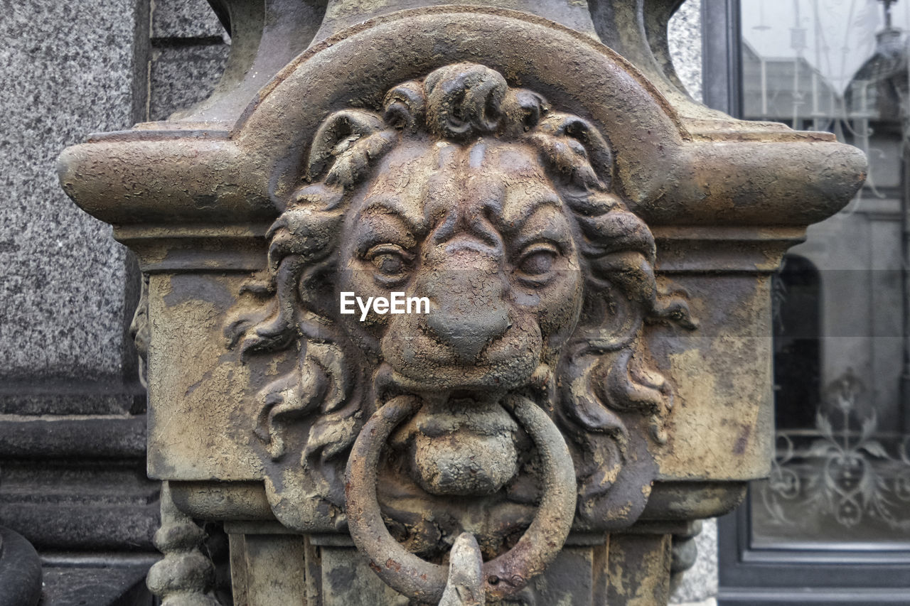 LOW ANGLE VIEW OF STATUE AGAINST WALL