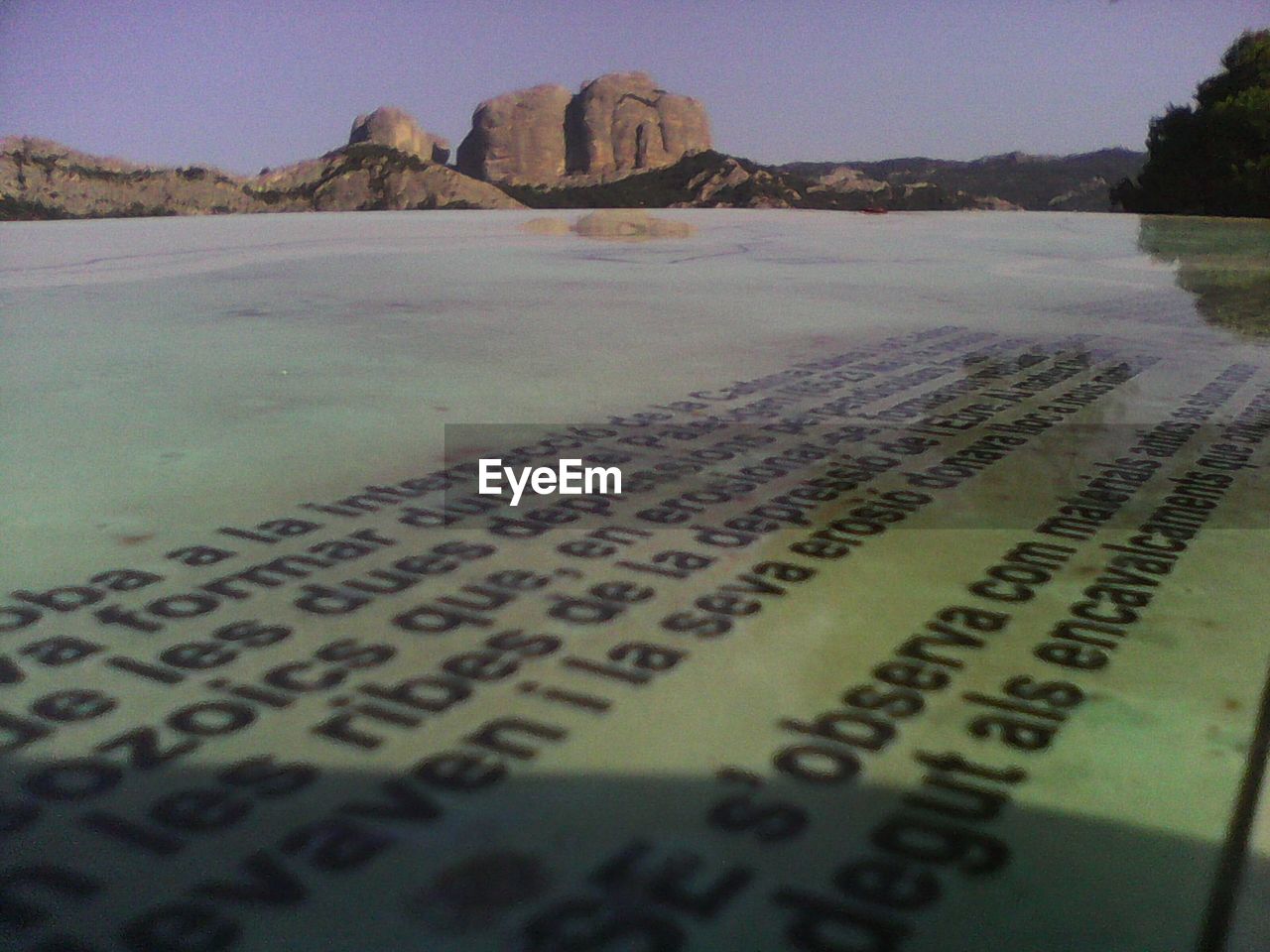 Close-up of text on beach against sky