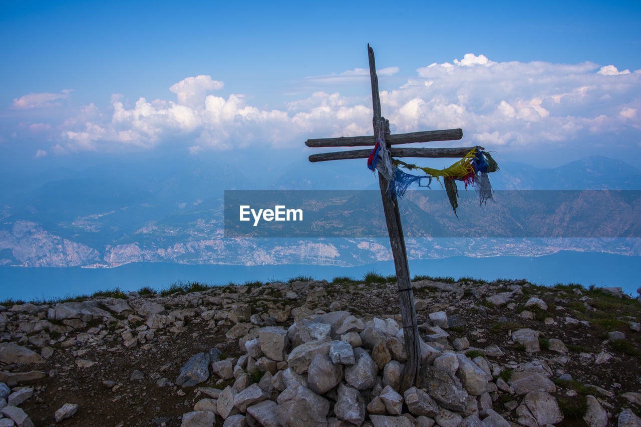 Wooden cross marks the peak of cima delle pozzette above malcesine, verona, italy