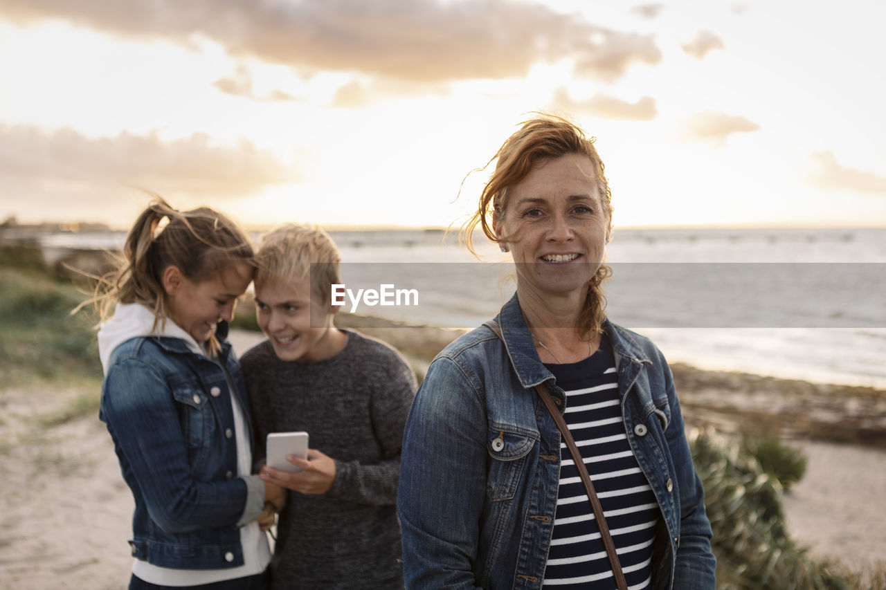 Portrait of smiling mother with children at beach