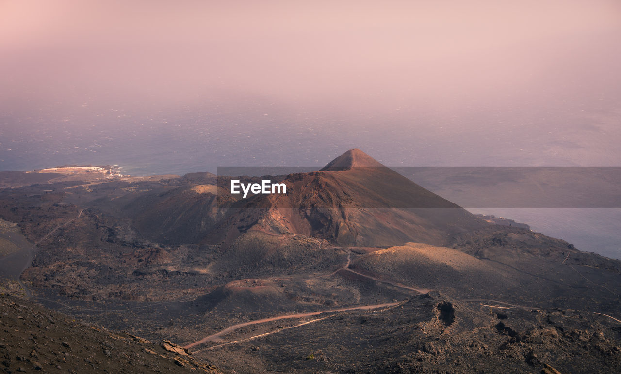 Majestic landscape of mountain range covered with clouds and valley with cloudy sky