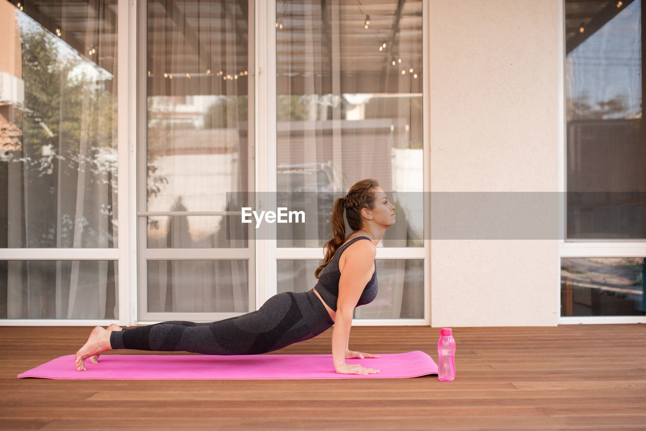 side view of young woman exercising in gym