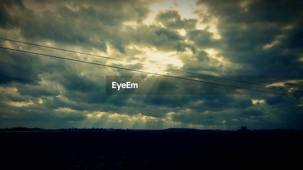 Silhouette landscape against cloudy sky