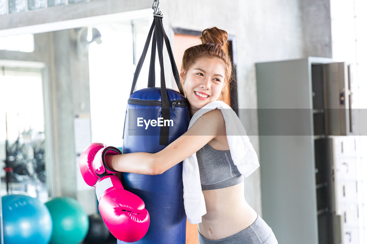 Young attractive woman with neatly bun hairstyle is taking rest after training