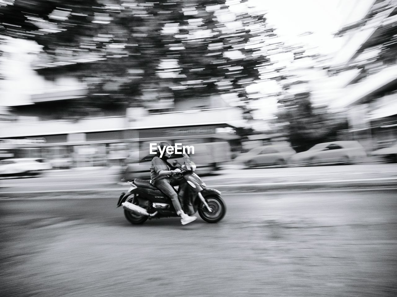 BLURRED MOTION OF MAN RIDING MOTORCYCLE ON BICYCLE