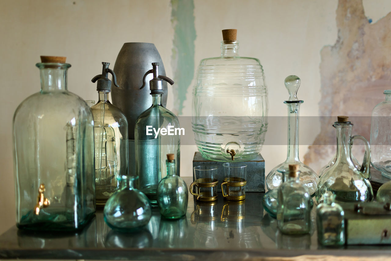 High angle view of glass bottles on table against wall