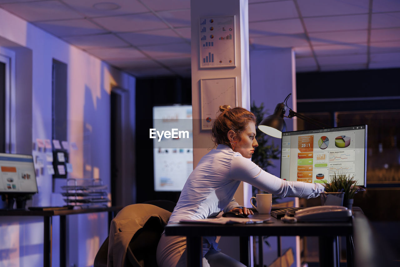 portrait of young woman using mobile phone in office