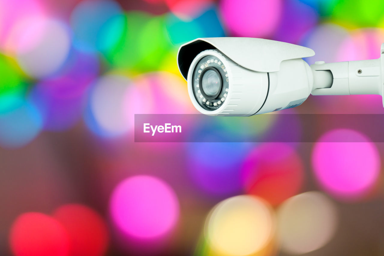 Close-up of security cameras against illuminated lights