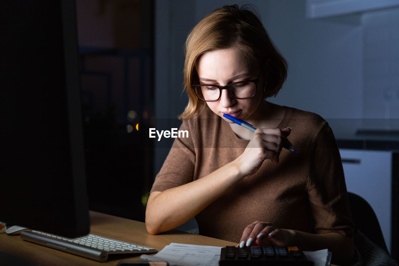 Businesswoman using computer on desk at home