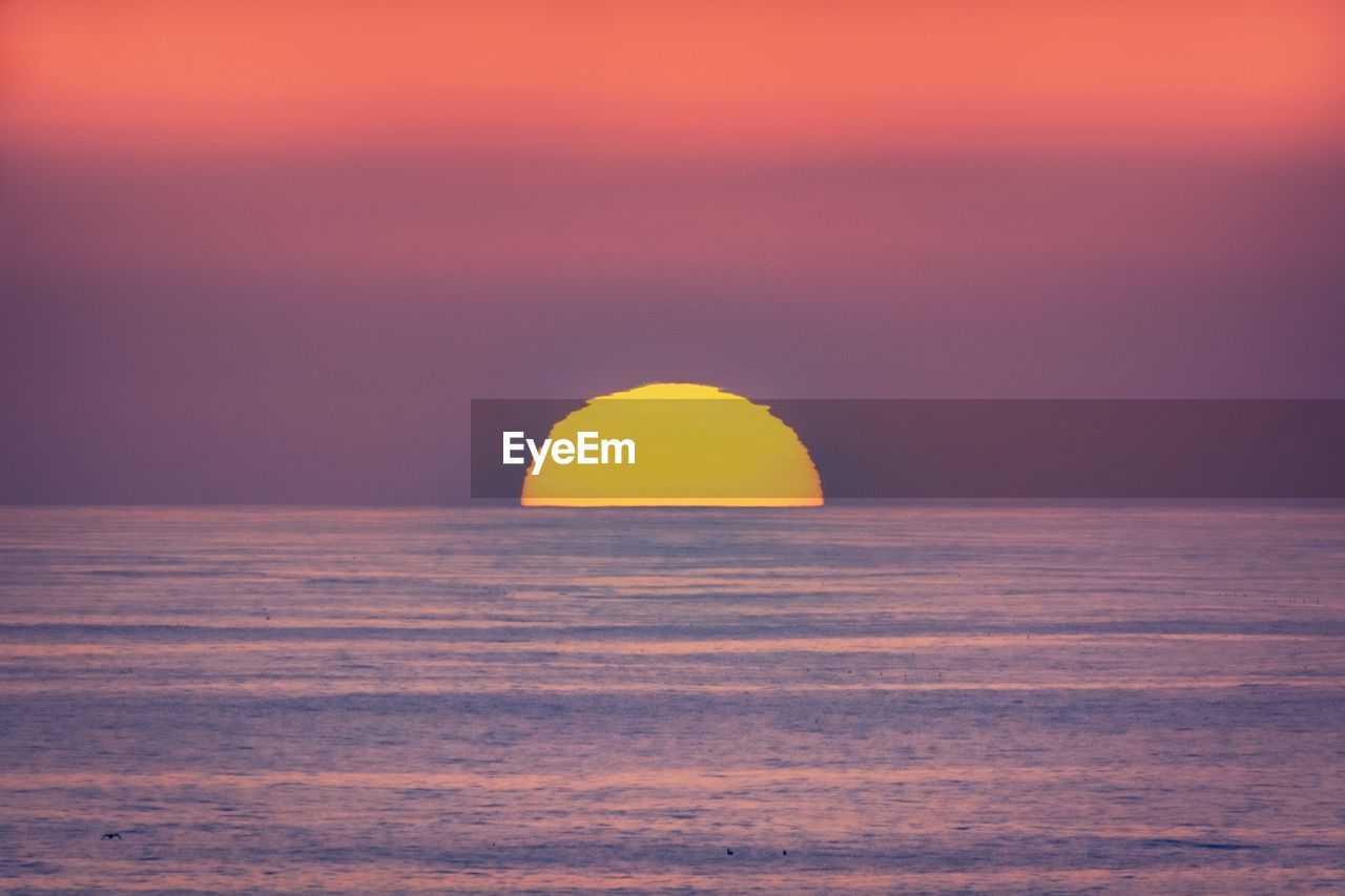 SCENIC VIEW OF SUNSET OVER SEA