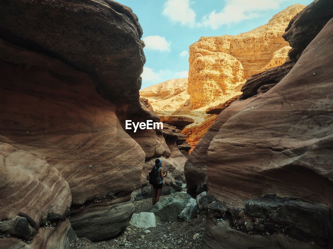 Rear view of woman standing amidst rocks at red canyon