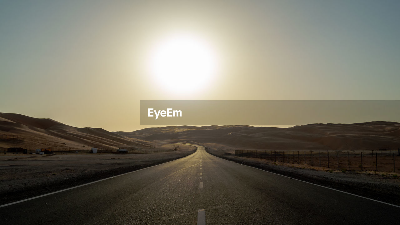 Empty road along countryside landscape