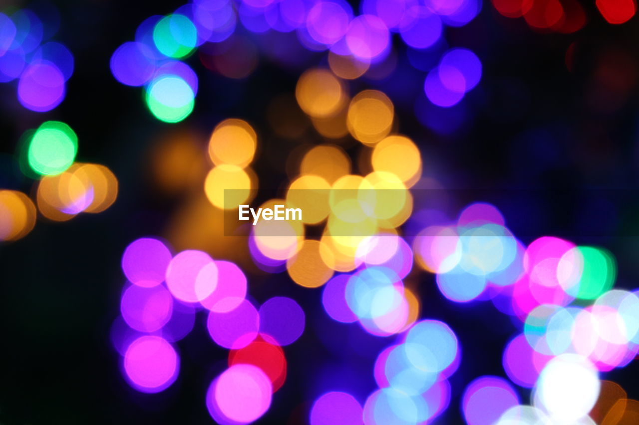 Defocused image of illuminated colorful christmas lights at night