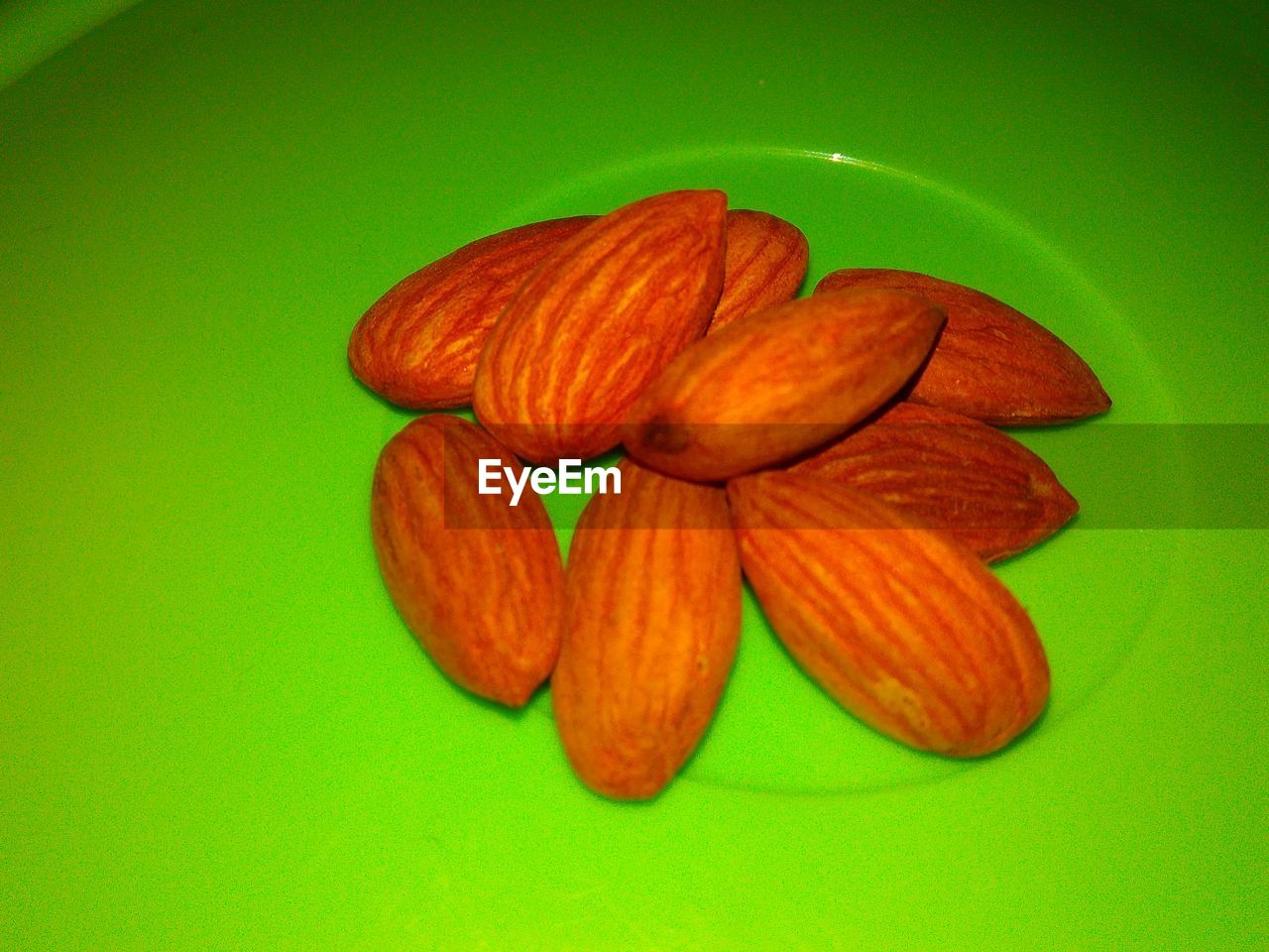 Close-up of almonds over green plate