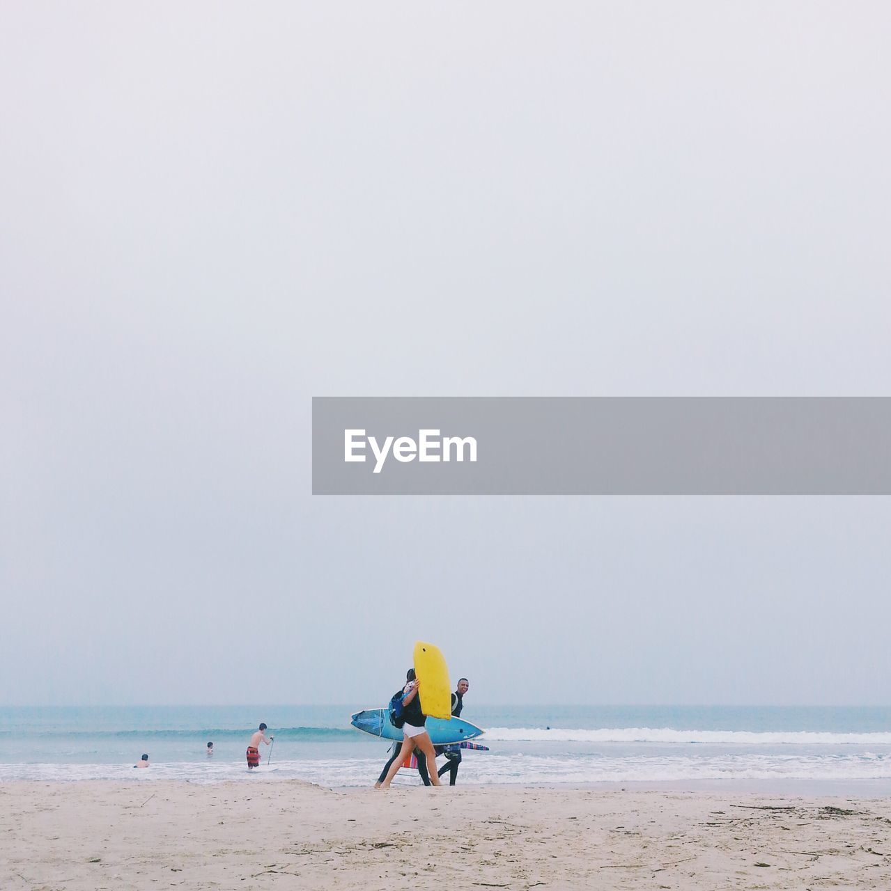 People at beach against clear sky