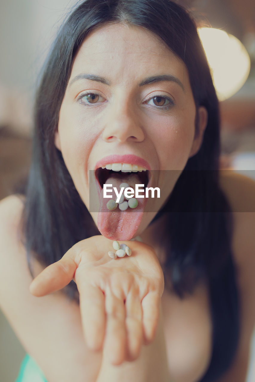 Close-up portrait of woman taking medicines at home