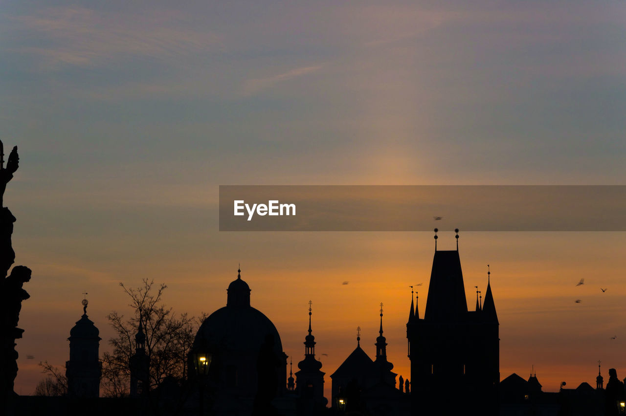 SILHOUETTE OF BUILDINGS AGAINST SKY AT SUNSET