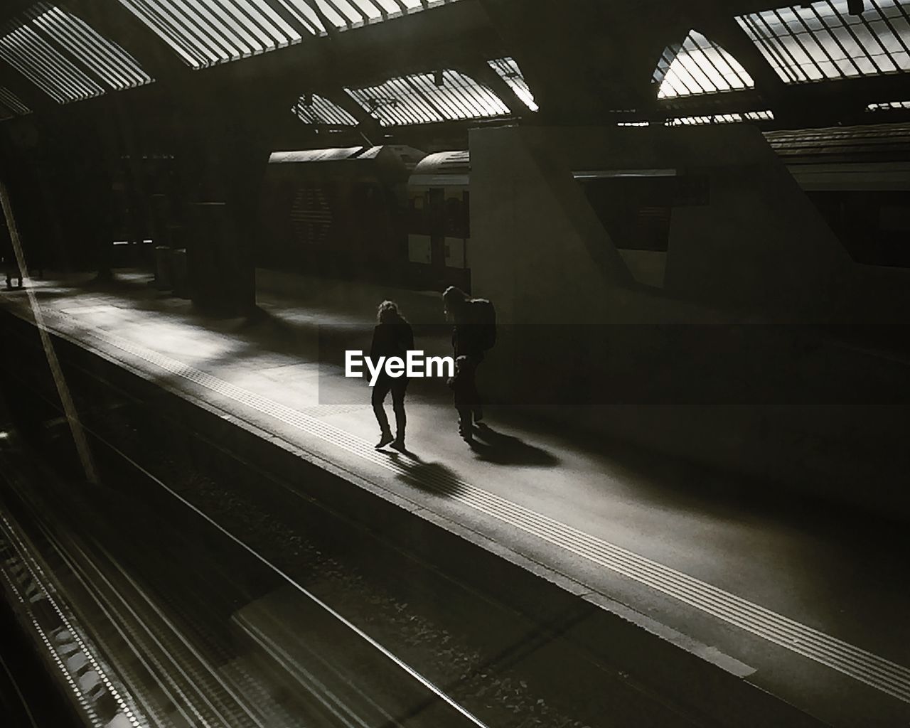 Passengers walking in railroad station platform