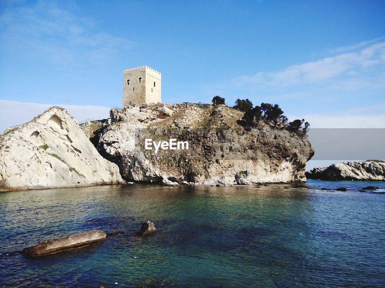 ROCK FORMATIONS ON SEA SHORE AGAINST SKY