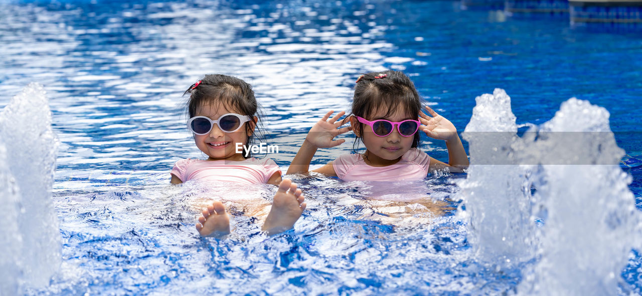 HIGH ANGLE VIEW PORTRAIT OF FRIENDS IN SWIMMING POOL