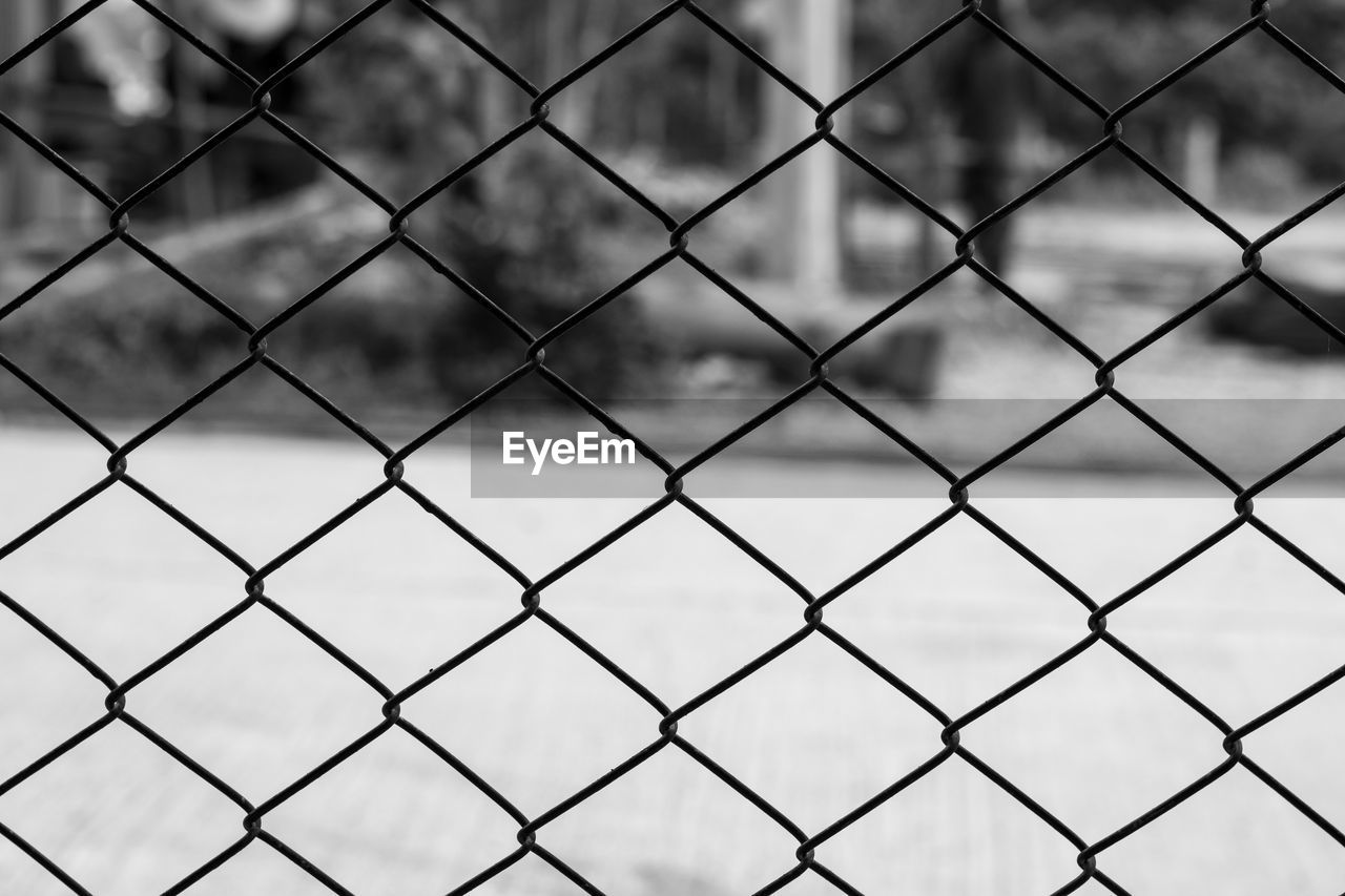 FULL FRAME SHOT OF CHAINLINK FENCE SEEN THROUGH METAL GRATE
