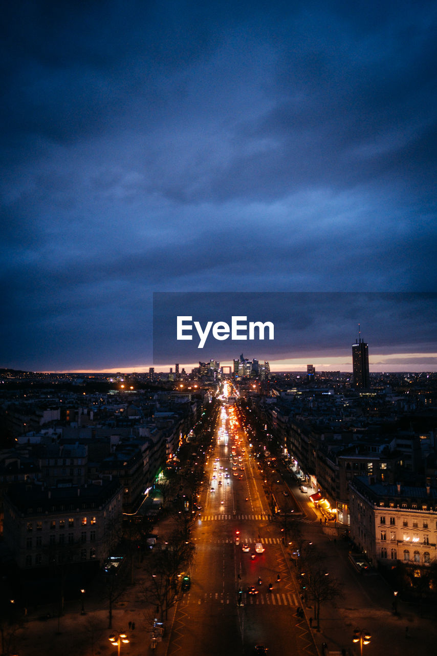 HIGH ANGLE VIEW OF ILLUMINATED CITY AGAINST SKY AT NIGHT