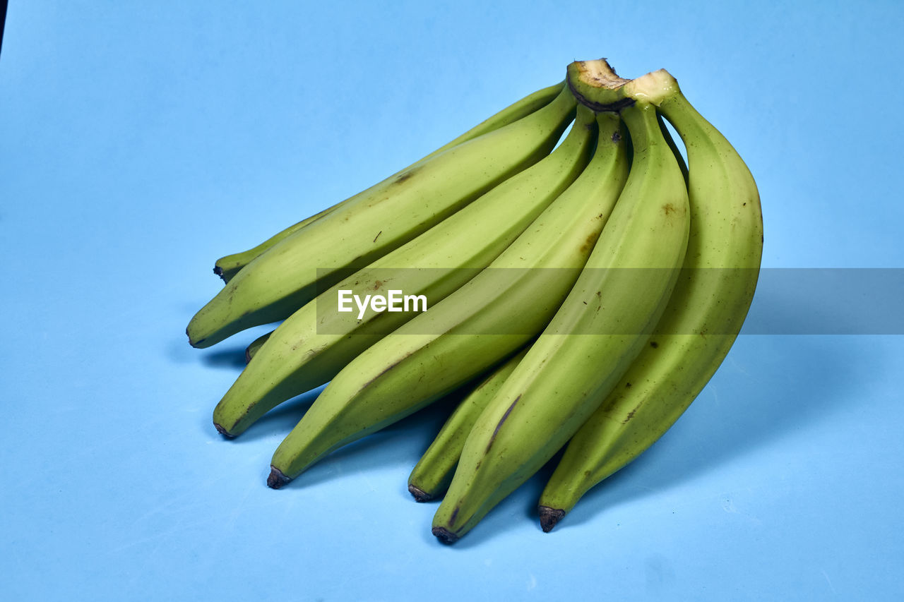 Fresh green banana on blue background, maqueno barraganete dominico