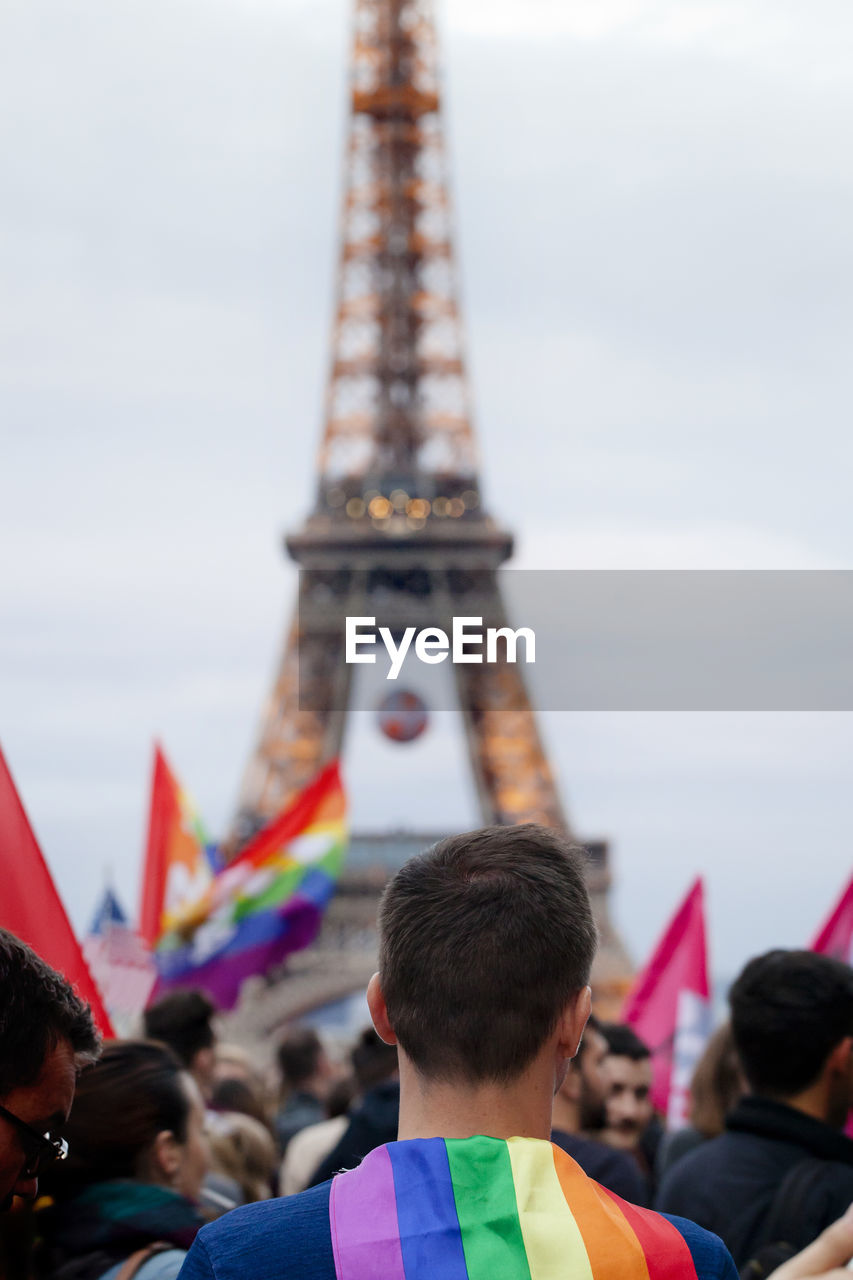 Gay pride parade by eiffel tower against sky