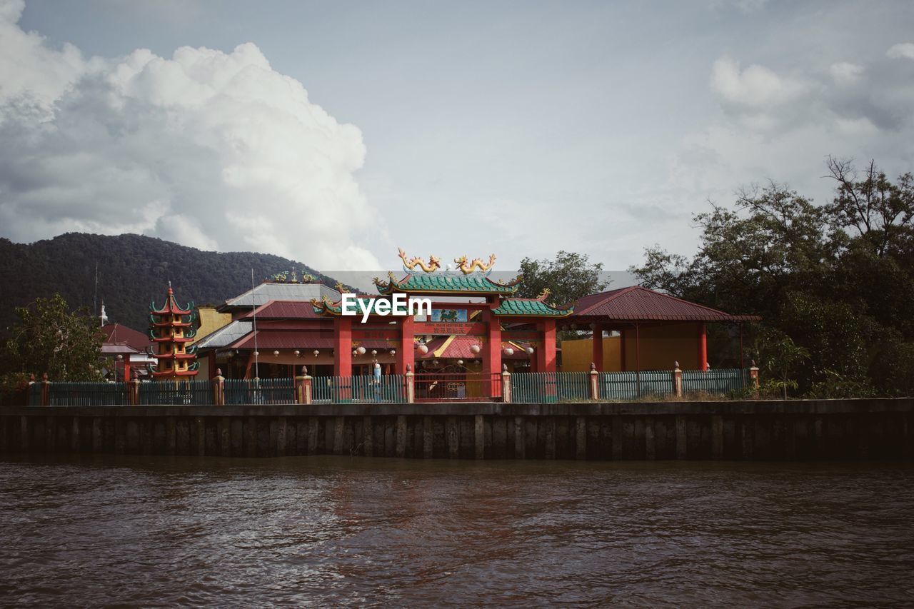 BUILT STRUCTURE ON LAKE AGAINST SKY