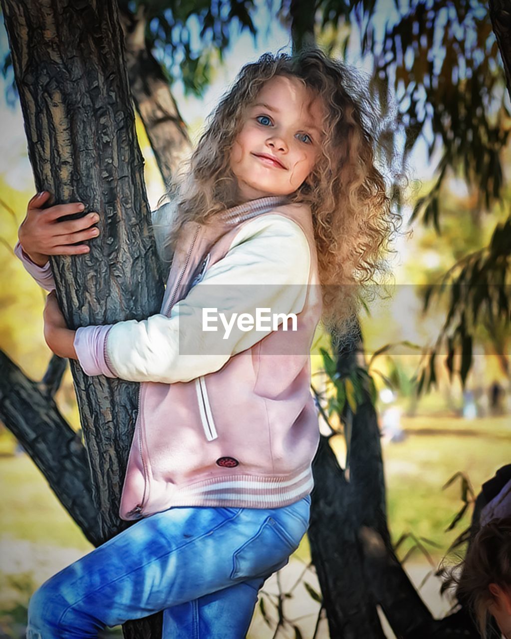 PORTRAIT OF CUTE GIRL WITH TREE TRUNK