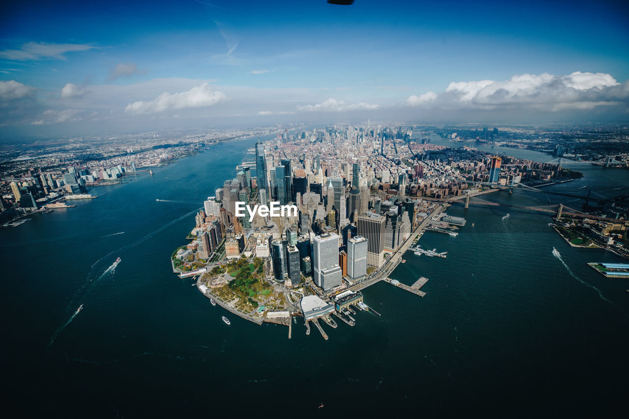 High angle view of sea and city buildings against sky