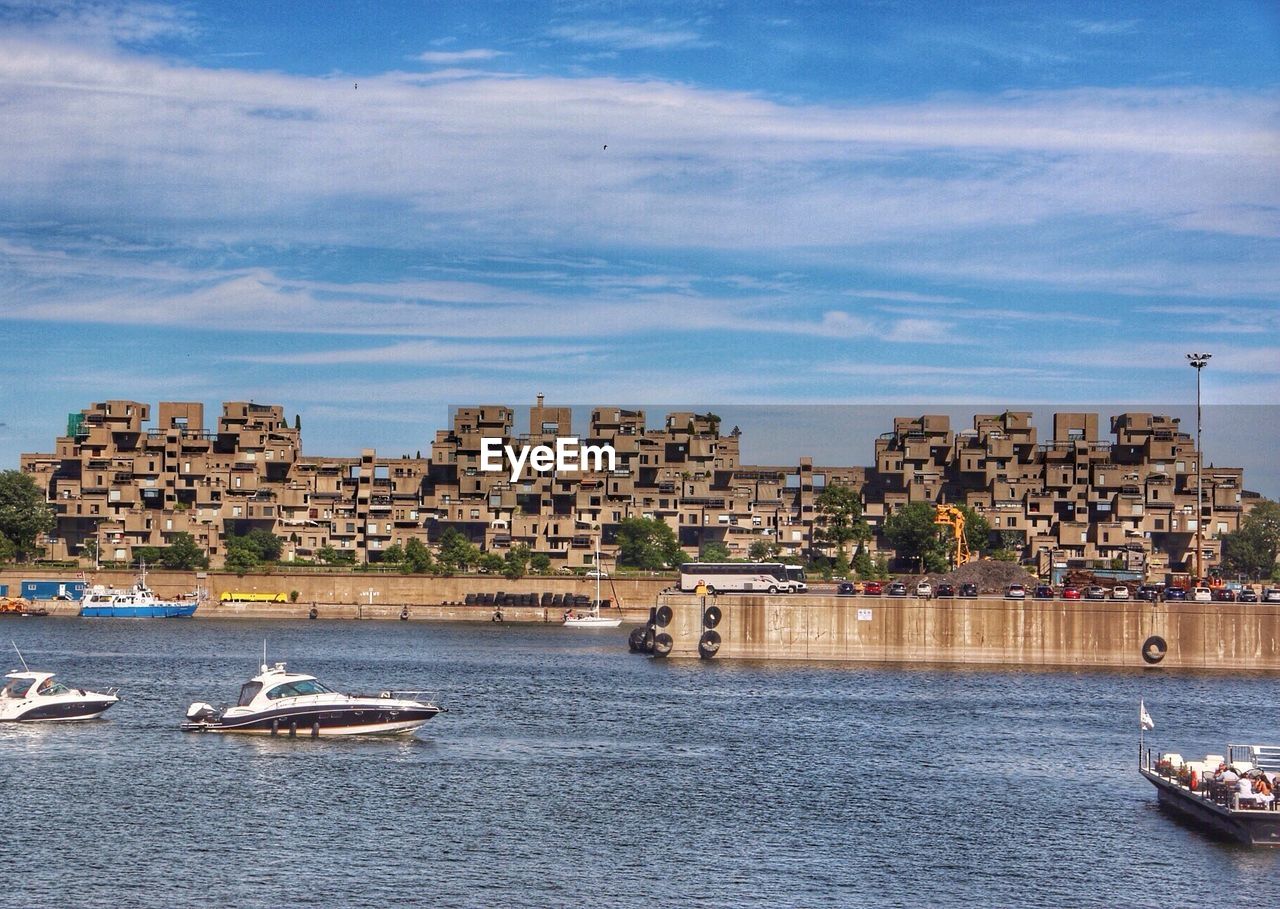 Boats in river against buildings and sky at vieux port during sunny day