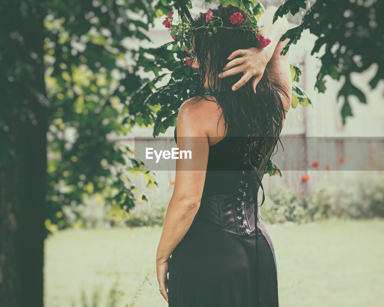 Side view of wet woman with long hair standing outdoors