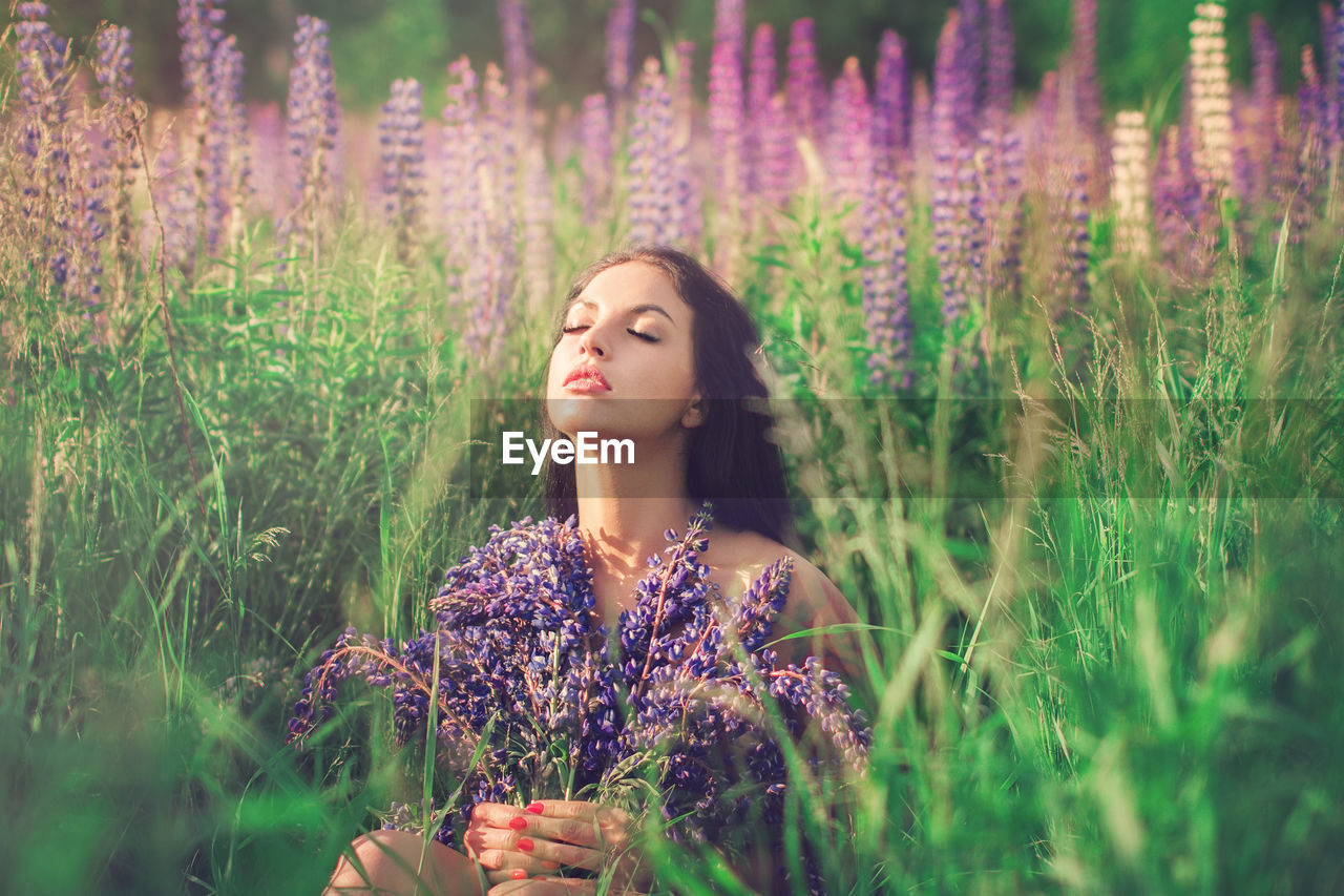 BEAUTIFUL YOUNG WOMAN STANDING ON FIELD