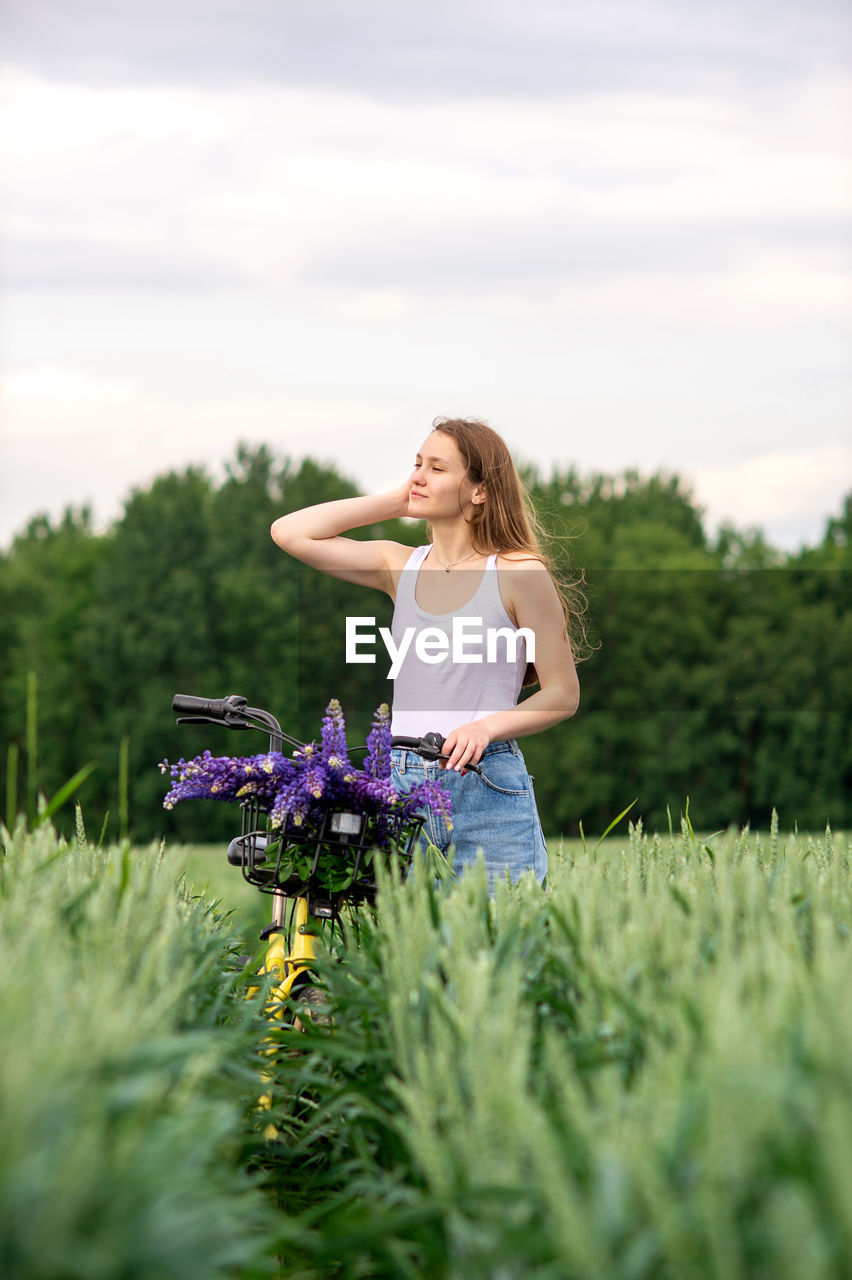 Side view of young woman standing on field