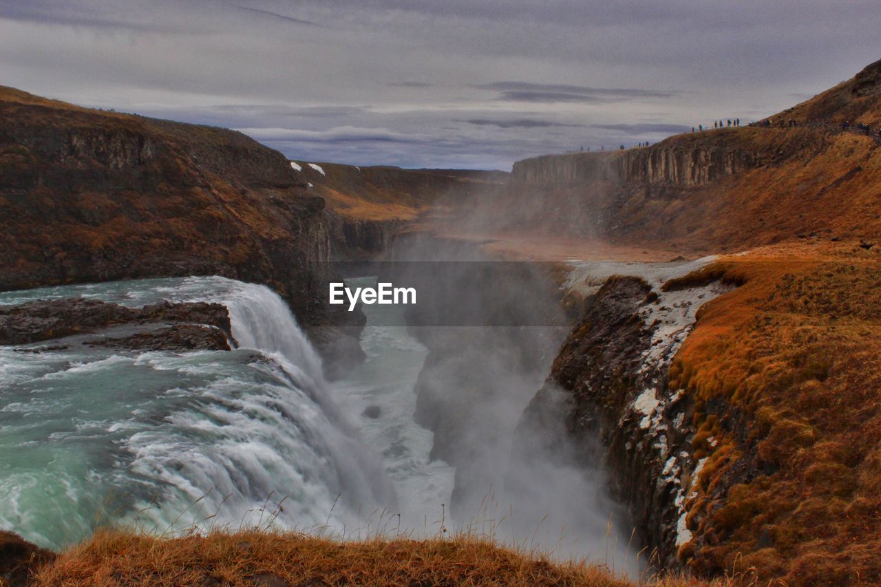 SCENIC VIEW OF WATERFALL ON SEA AGAINST SKY