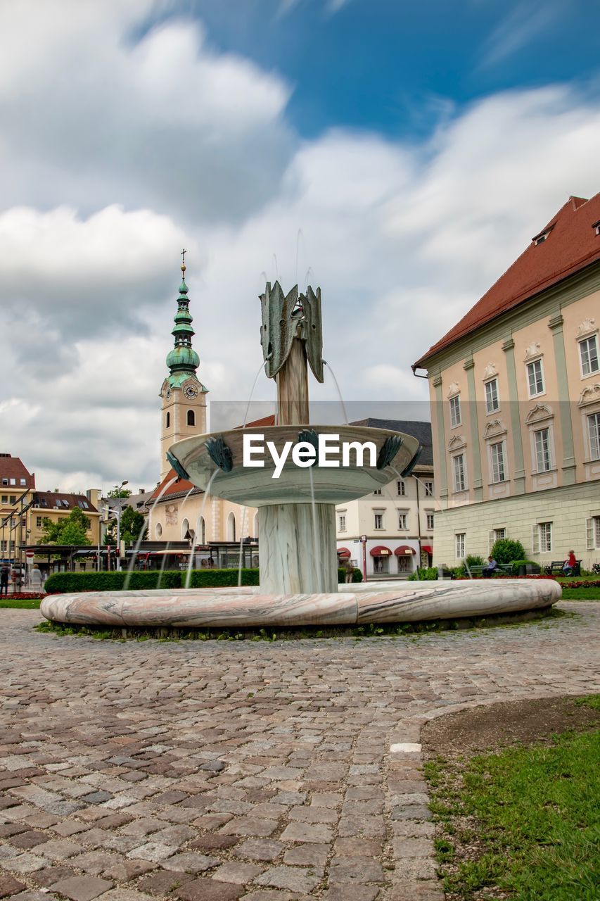 View of buildings in city against cloudy sky