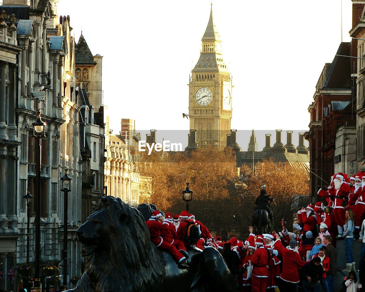 Men wearing santa claus costume standing against big ben