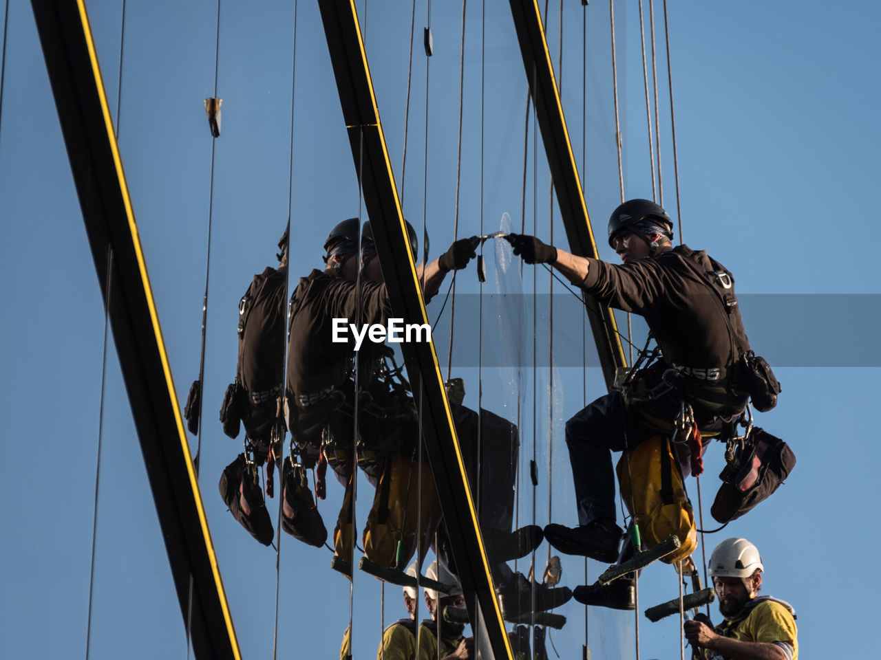 LOW ANGLE VIEW OF PEOPLE ON ROPE AGAINST SKY