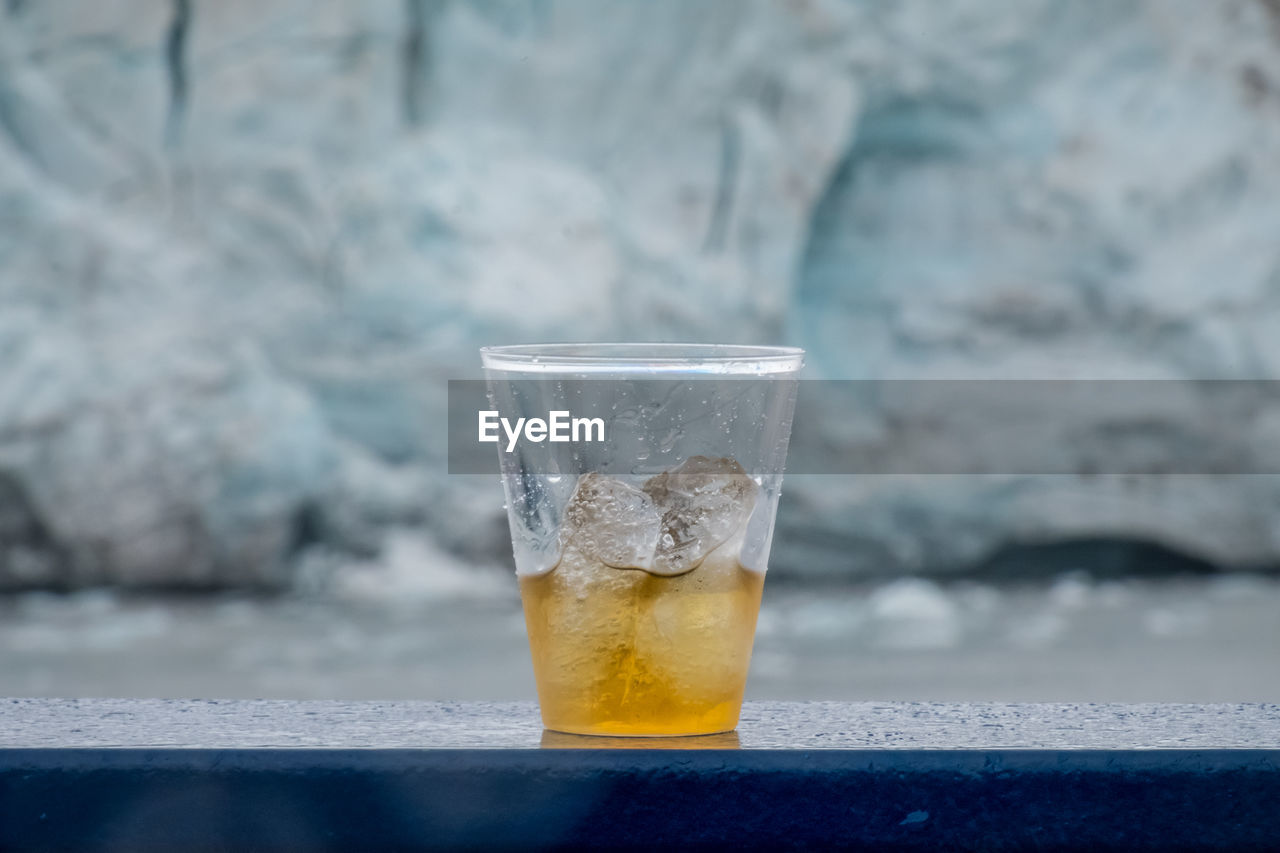 Close-up of drink on railing