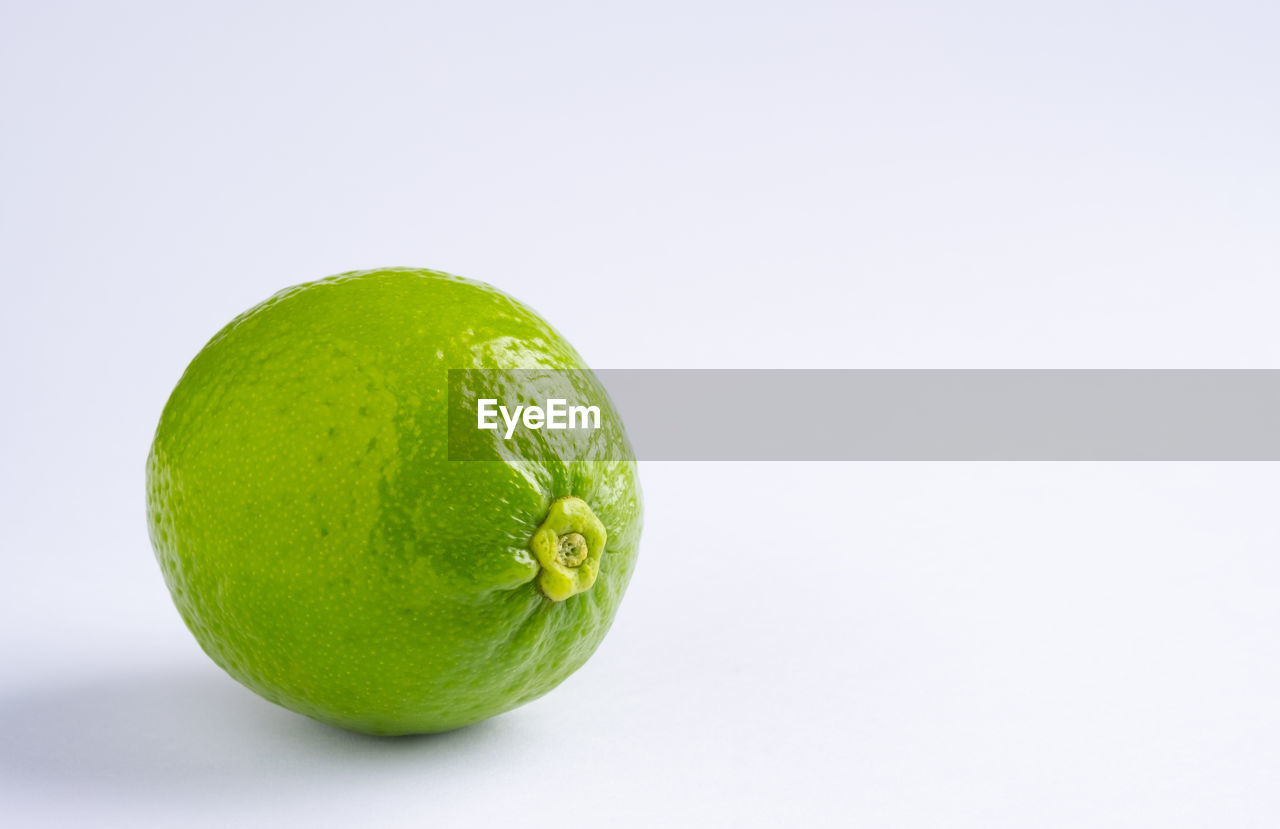 CLOSE-UP OF LEMON AGAINST WHITE BACKGROUND