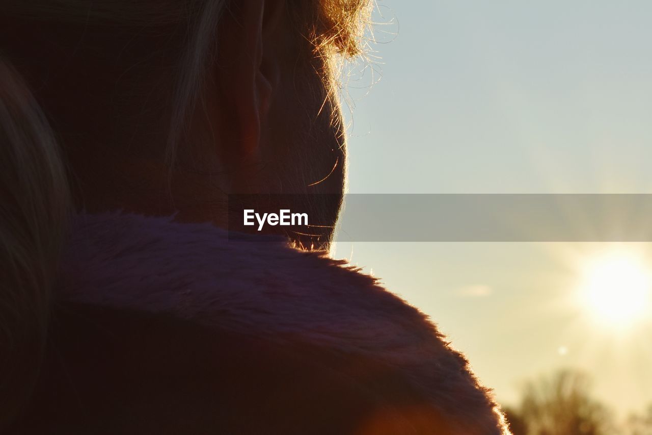 Close-up of woman against sky during sunset