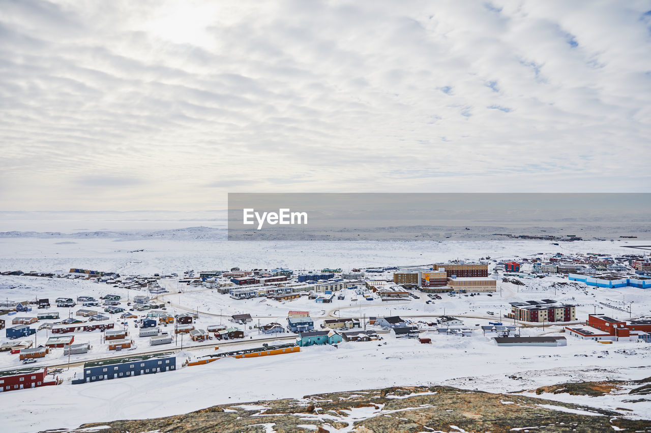 High angle view of cityscape by sea against sky