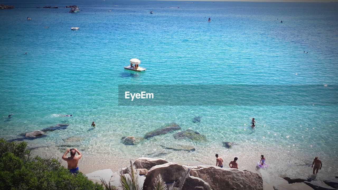 HIGH ANGLE VIEW OF PEOPLE ENJOYING AT BEACH