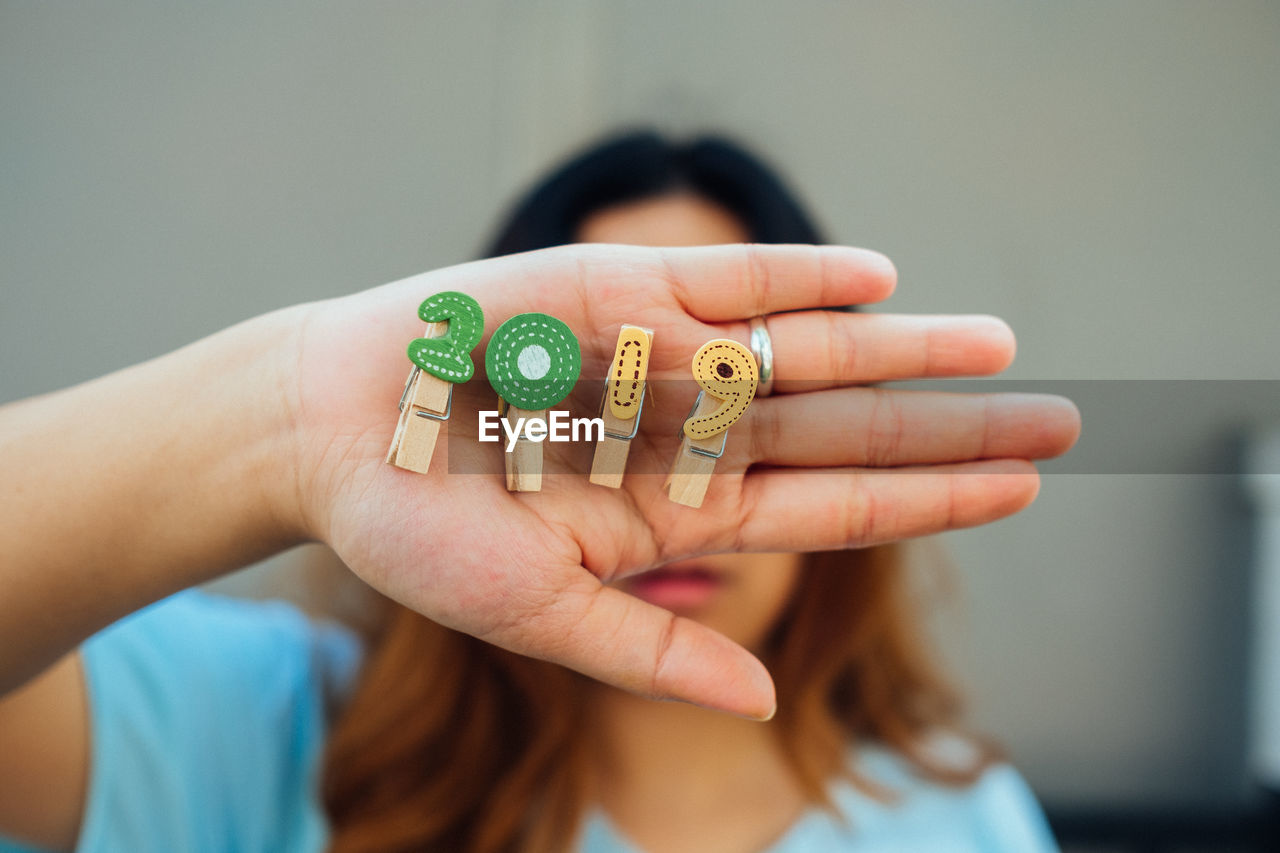 Close-up of woman holding clothespin with 2019 numbers